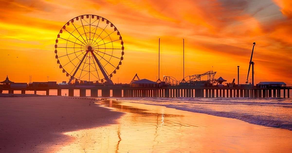 A view of the Atlantic City Boardwalk from the beach during a sunset