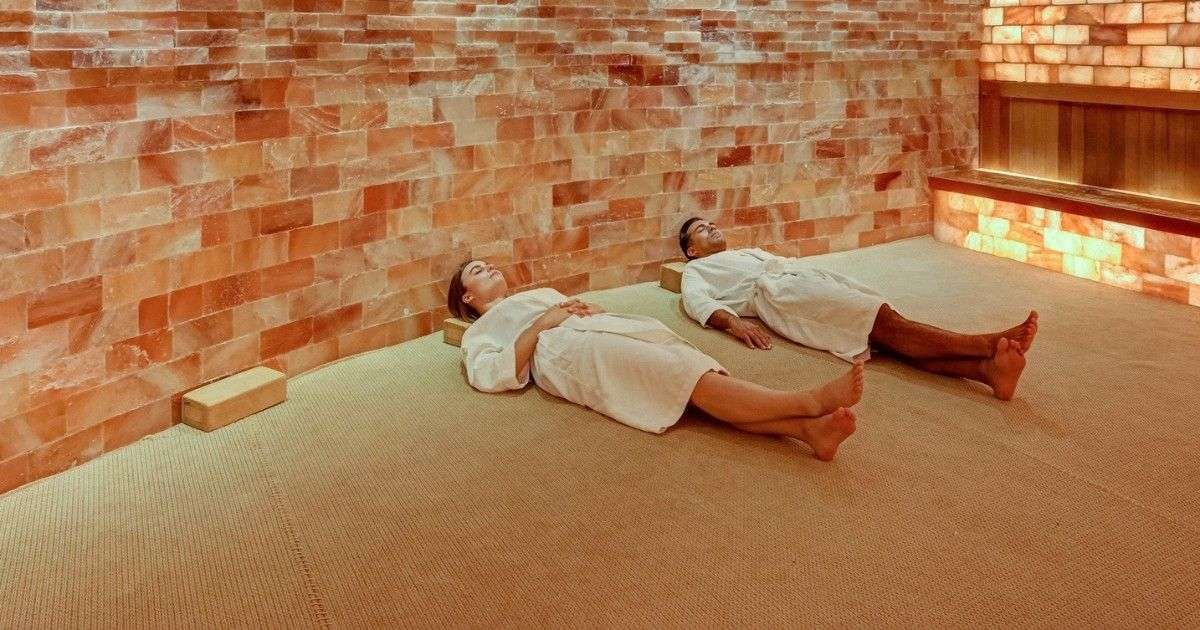 Two people lying on the floor of a brick sauna in SoJo Spa Club