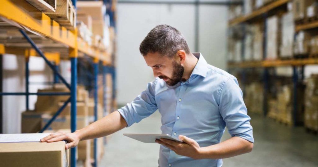 A trusted employee taking inventory at a large warehouse. 