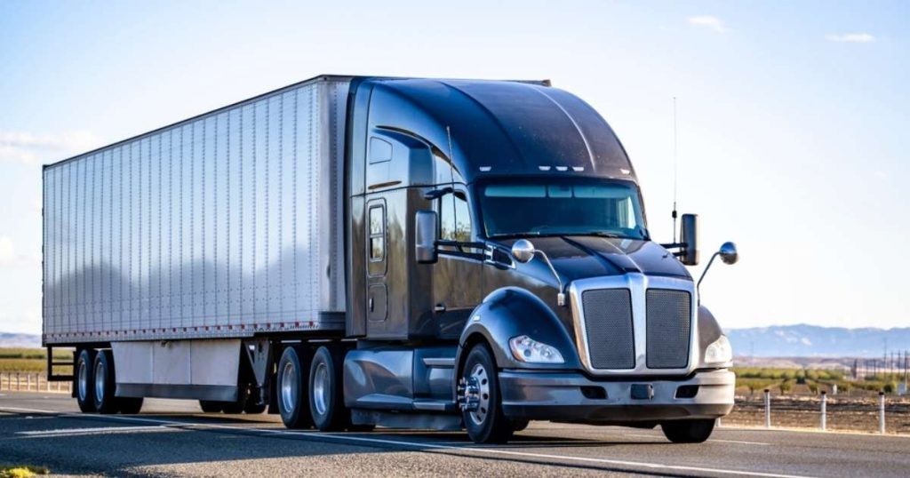 Blue moving truck driving on the highway during a relocation.