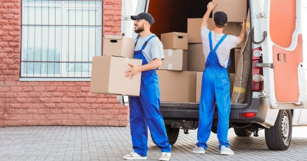 Two professionals from a moving company in Emerson NJ hauling boxes out of a truck