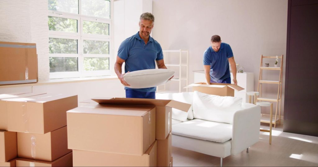 two movers packing away furniture into boxes