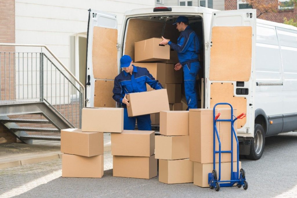 Two Montclair movers organizing boxes to load into the back of a truck