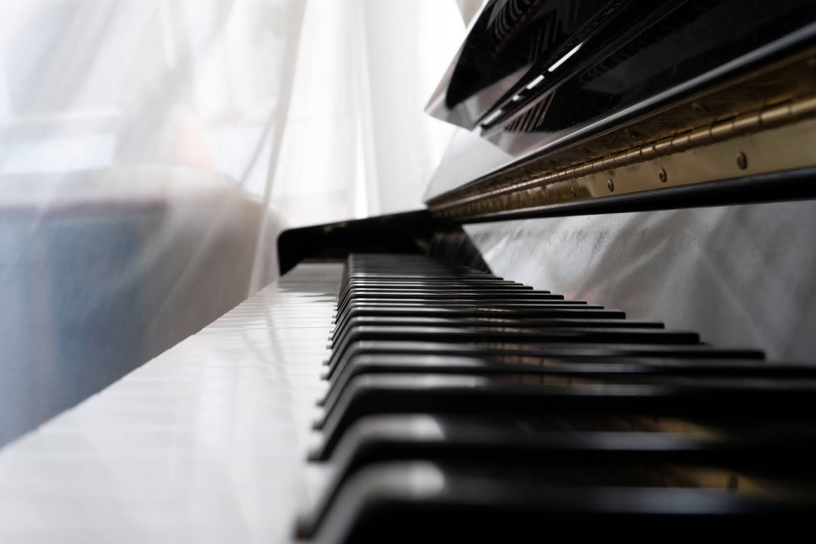 Close up of piano keys under a plastic sheet